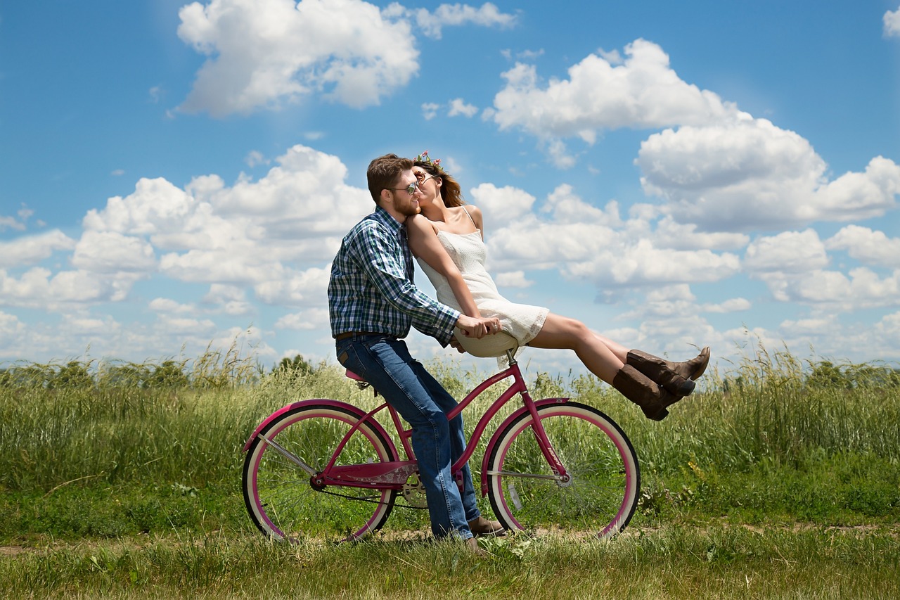 A man and a woman riding a bike.