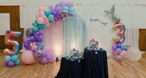 A birthday party with a cake and balloons.